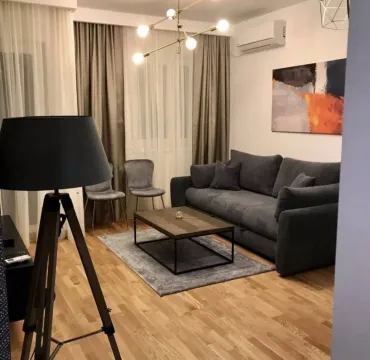 Dnevna soba sa udobnom tamnom garniturom, klub stolićem i modernim osvjetljenjem. - image 4