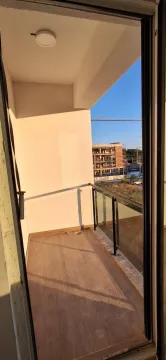 Pogled na nenamješten balkon sa staklenom ogradom i drvenom podnom oblogom. - image 6
