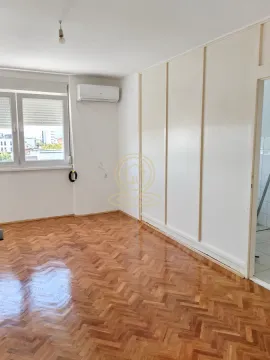 Prazna soba sa parketom na podu i ugrađenim plakarom. - image 6