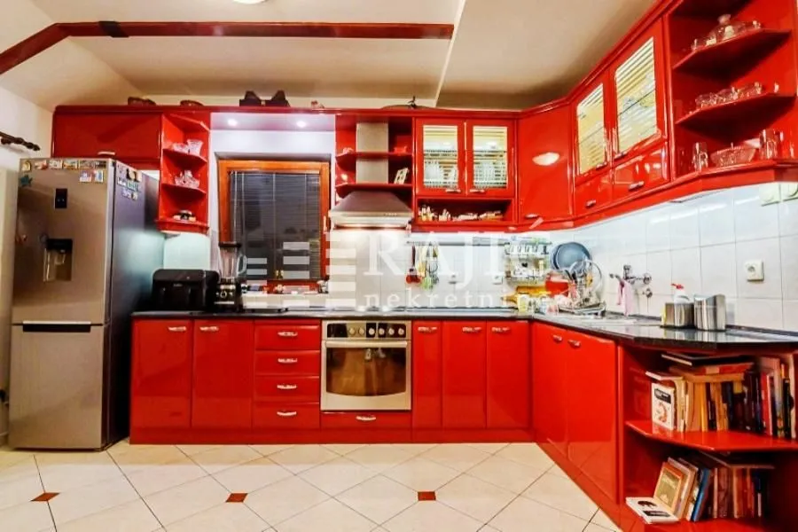 Spacious kitchen with bright red cabinets and built-in appliances.