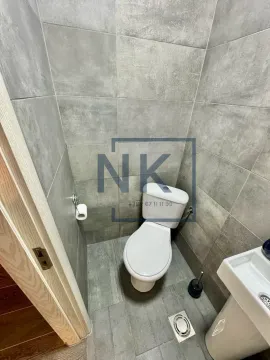 Manje kupatilo obloženo sivim pločicama sa šoljom i umivaonikom. - image 9