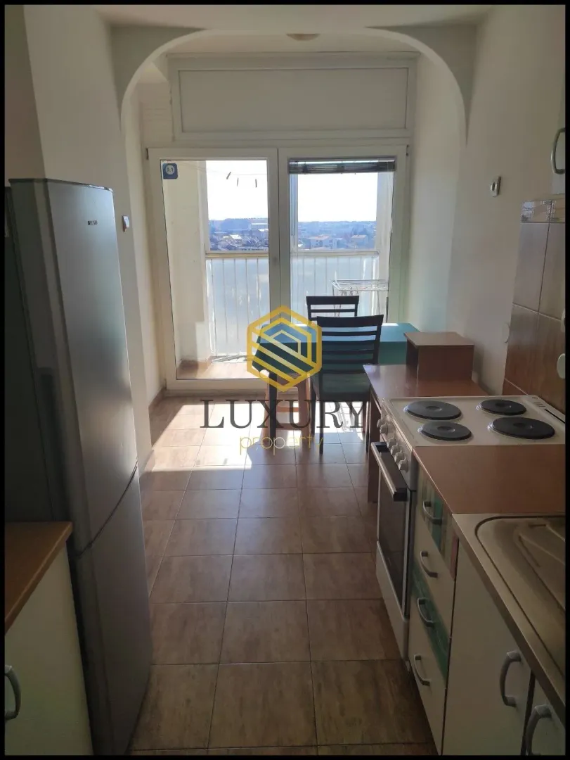 Small kitchen with a dining table and access to the terrace.