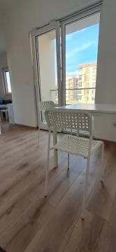Dnevna soba sa trpezarijskim stolom, bijelim stolicama i pogledom na terasu. - image 8