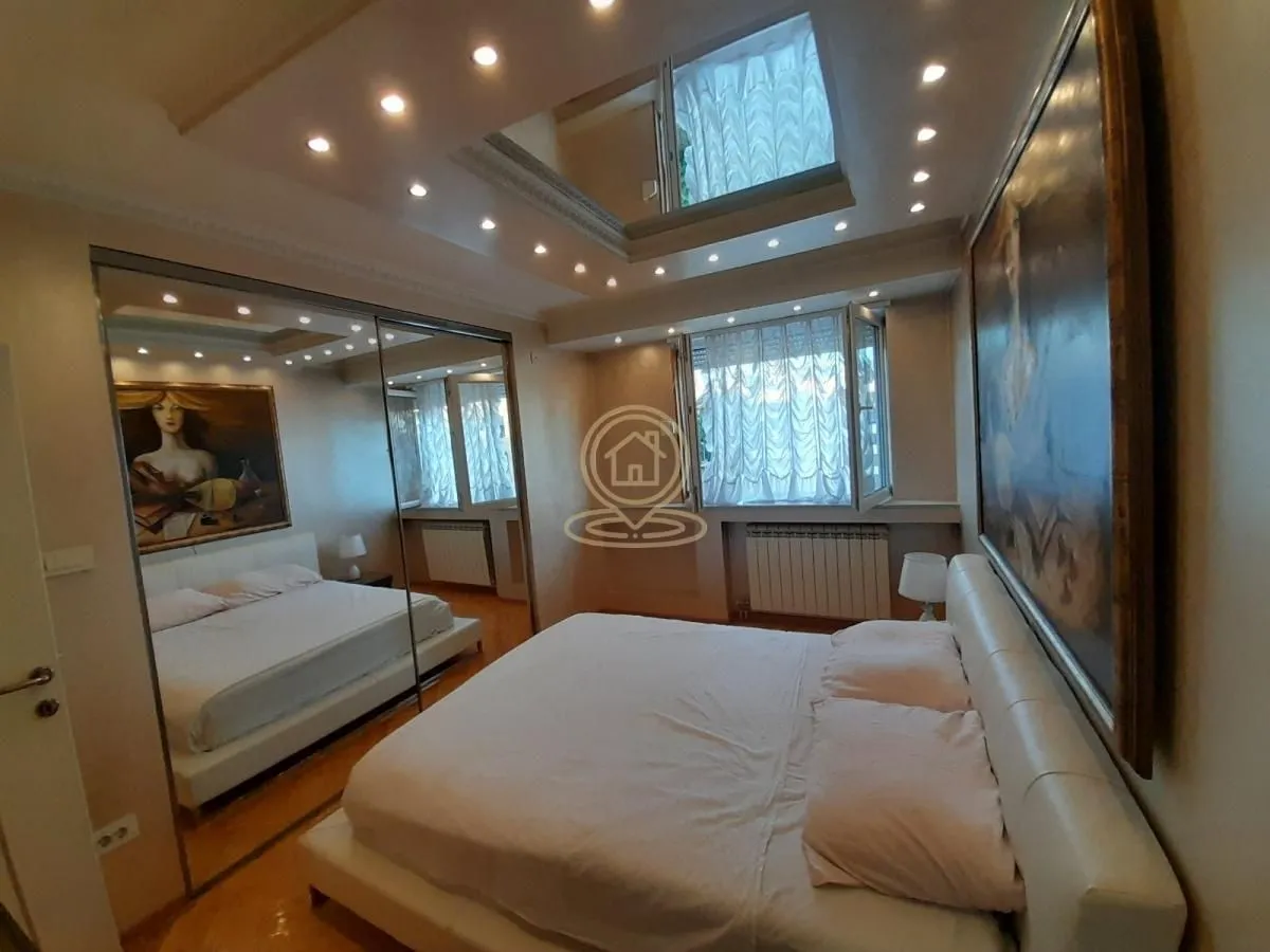 Spacious bedroom with a double bed, large mirror, and wall art.
