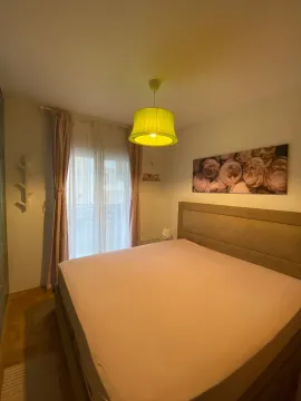 Furnished bedroom with a double bed, window, and a hanging lamp. - image 7