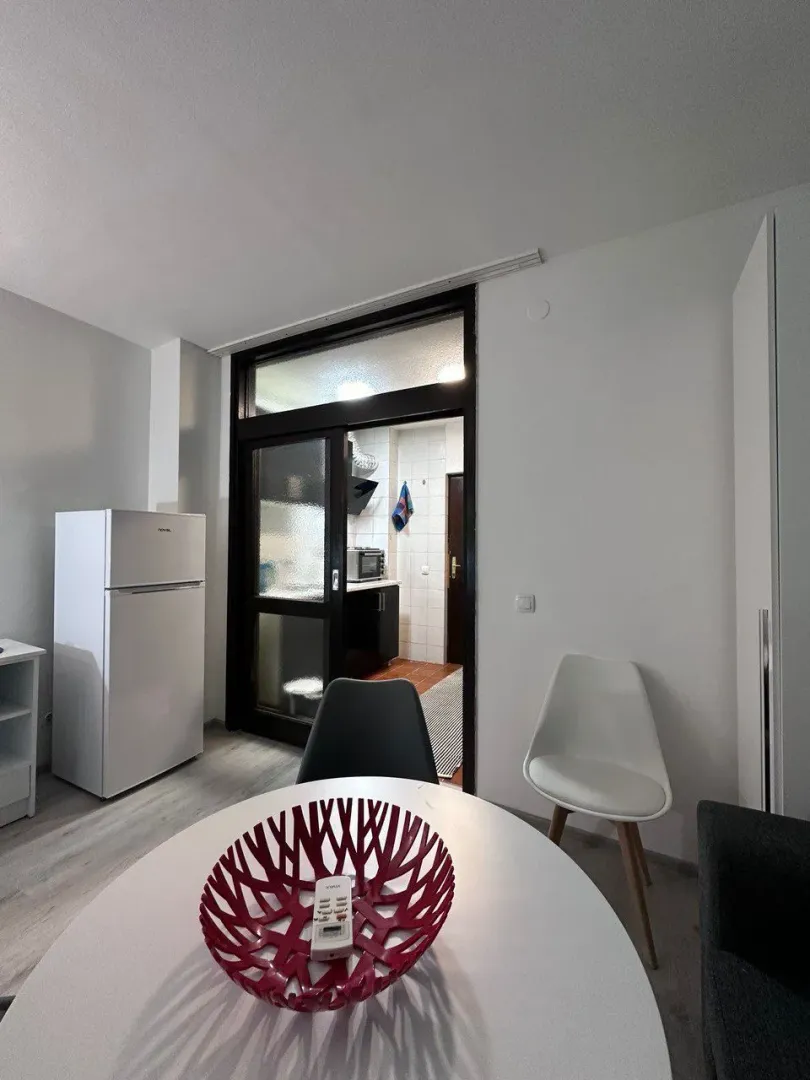 Dining area with a round table and a view into the kitchen.
