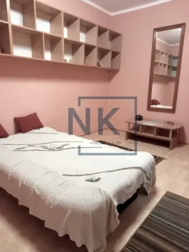 Furnished bedroom with a bed, wall shelves, and a mirror. - image 6