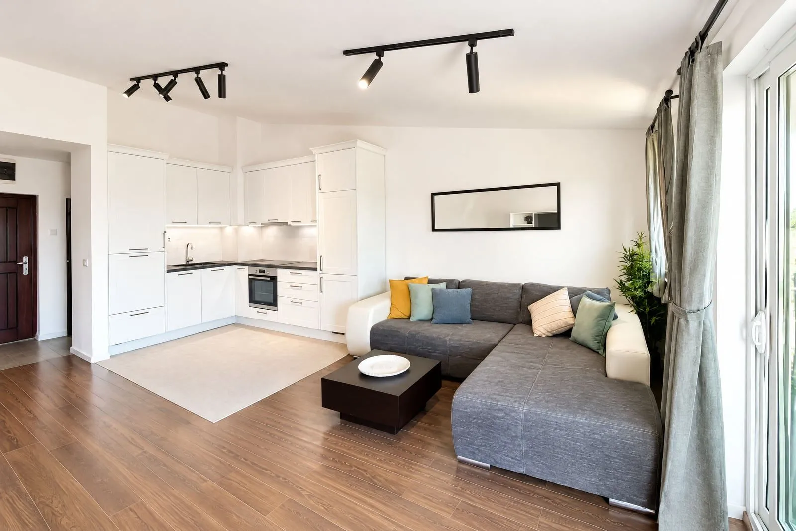 Modern and bright living room with a sofa and corner kitchen.