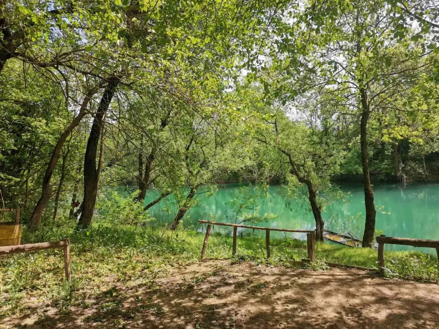 Zemljište pored rijeke okruženo zelenilom i drvećem.