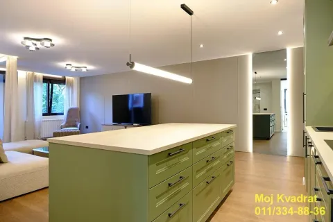 Moderna kuhinja sa zelenim ostrvom i pogledom na dnevni boravak. - image 6