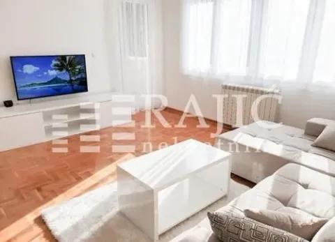 Bright living room with a sofa set, TV, and parquet flooring. - image 11