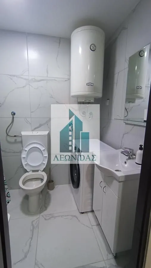 Bathroom equipped with sanitary fixtures, a sink, a washing machine, and a water heater.