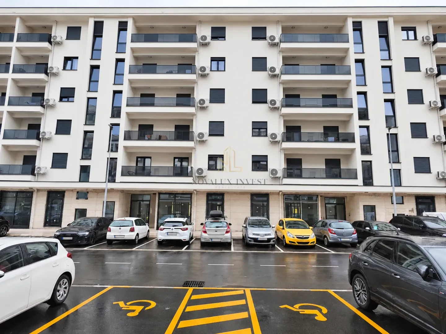 Exterior view of the residential building with a parking lot in front.