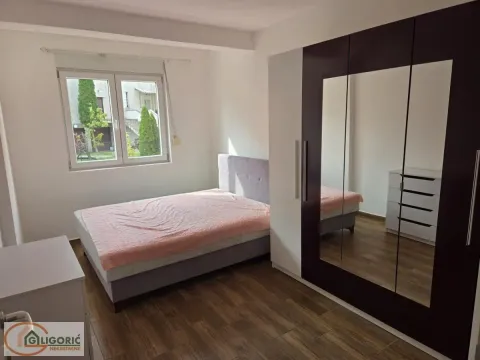 Furnished bedroom with a double bed, large mirrored wardrobe, and a window. - image 9