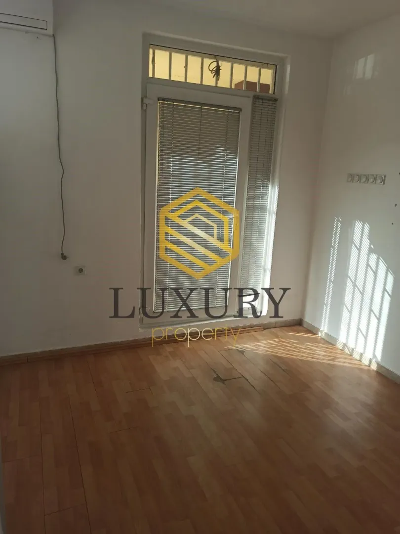 Empty room with hardwood floors and a balcony door.