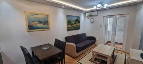 Svijetla dnevna soba sa kaučem, trpezarijskim stolom i umjetničkim slikama na zidu. - image 5