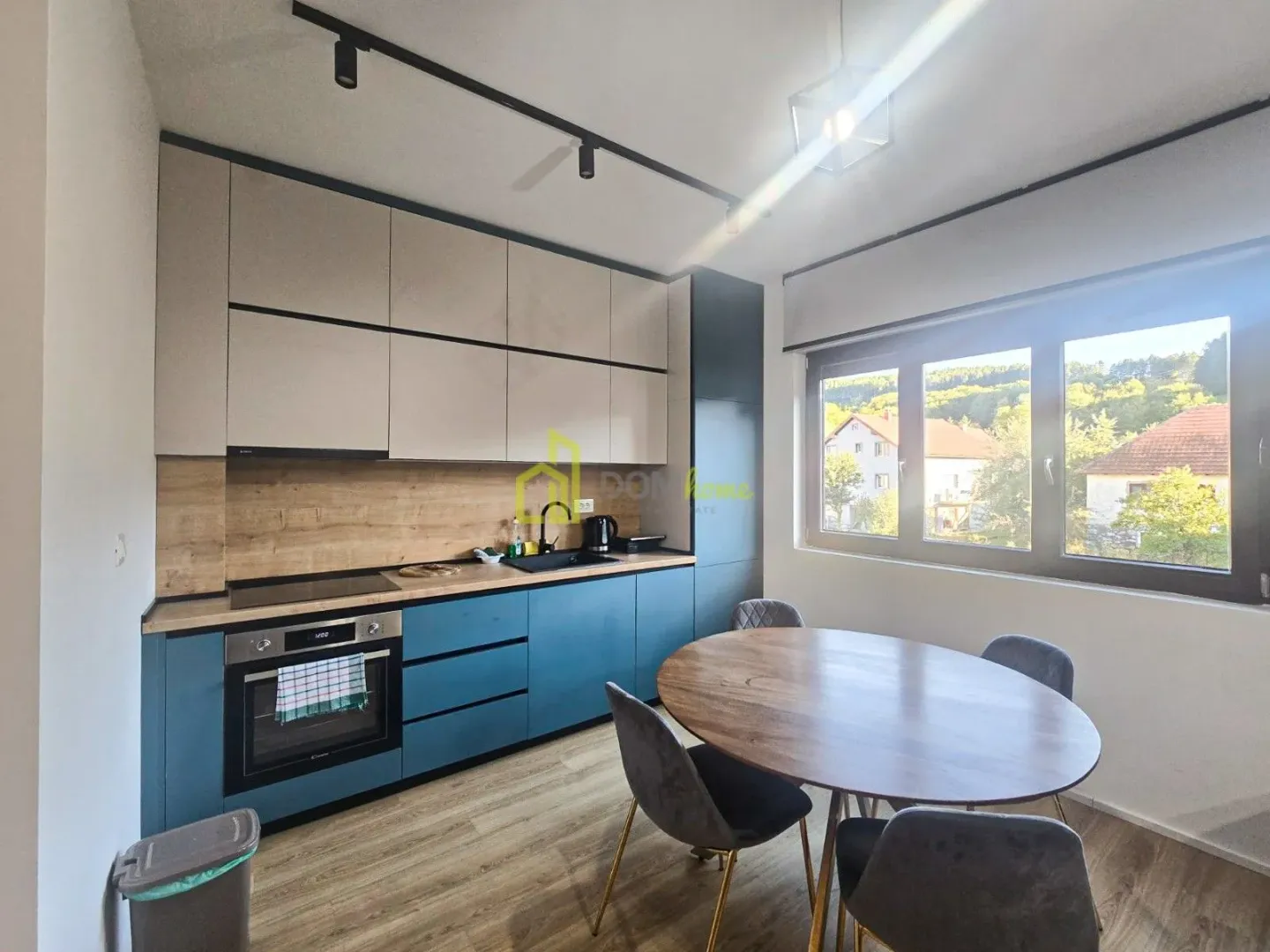 Modern kitchen with a dining table and a window overlooking the yard.