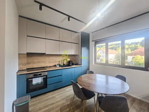 Modern kitchen with a dining table and a window overlooking the yard. - image 4