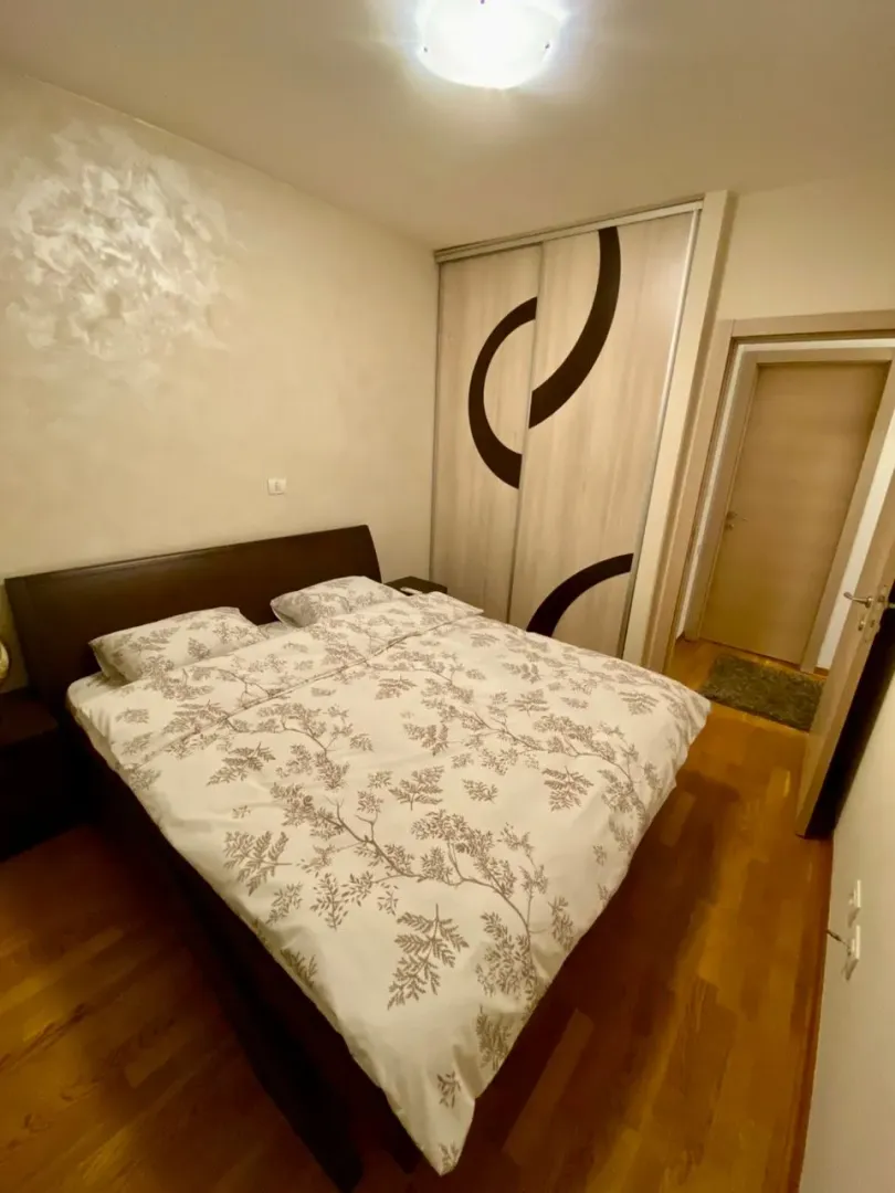 Furnished bedroom with a double bed and built-in wardrobe.
