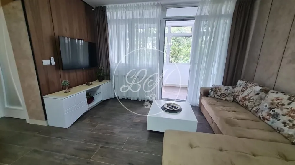 Living room with a sectional sofa, TV, and access to the terrace.