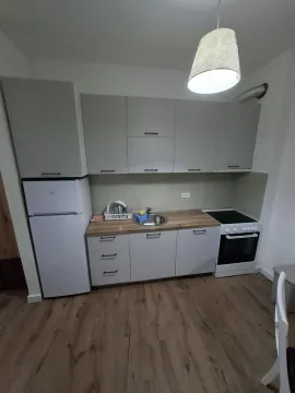 Small kitchen with white cabinets, refrigerator, and stove. - image 3