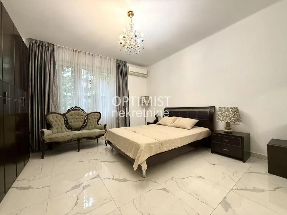 Spacious bedroom with a double bed, wardrobe, and a sofa by the window.