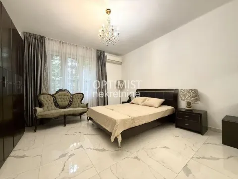 Spacious bedroom with a double bed, wardrobe, and a sofa by the window. - image 9