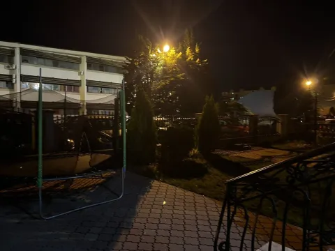Dvorište zgrade noću sa popločanim dijelom i zelenilom. - image 20