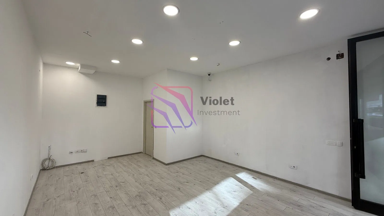Empty bright room with white walls and wooden flooring.