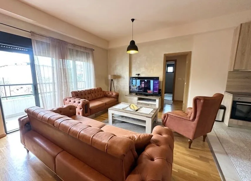 Living room with a sofa set, coffee table, and television, with access to the terrace.