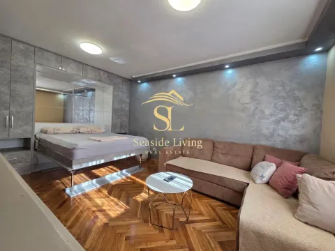 Living room with a sectional sofa, bed, and parquet flooring. - image 10