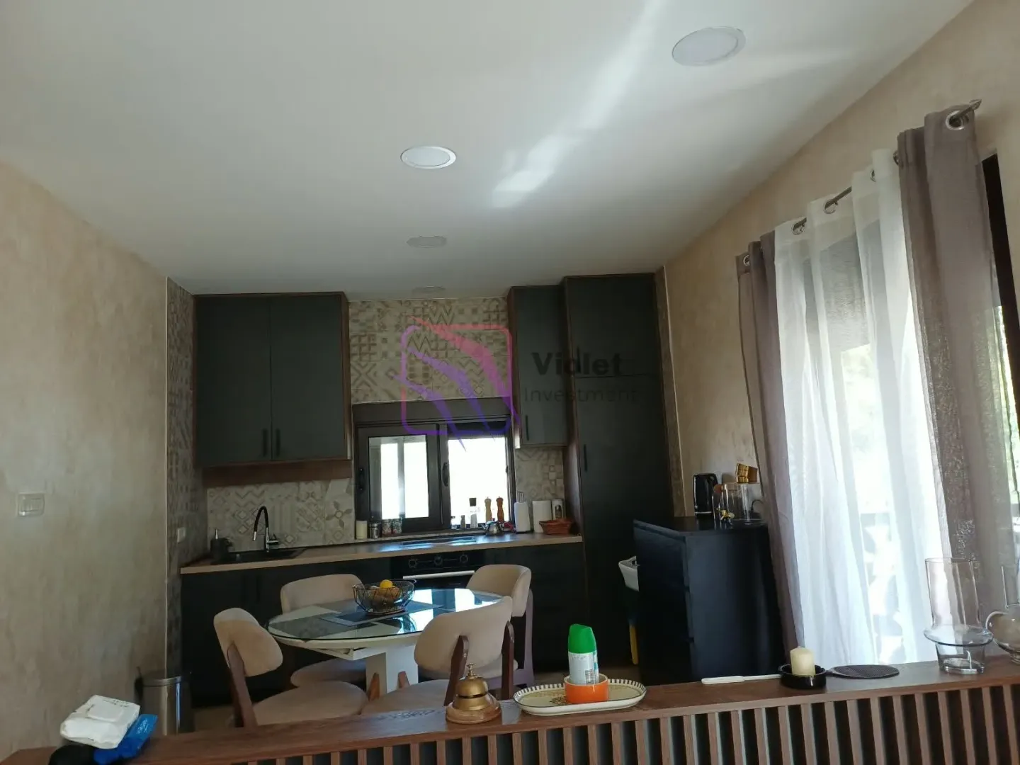 Kitchen with dark cabinets and a dining table with chairs.