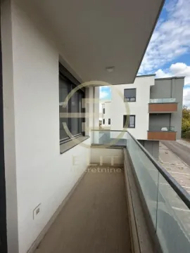 Pogled na prostrani balkon sa staklenom ogradom i pogledom na okolne zgrade. - image 6
