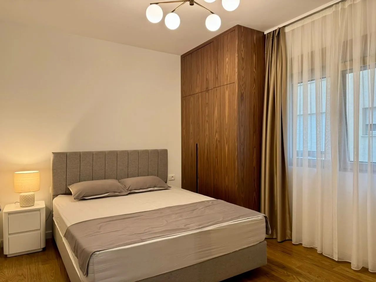 Furnished bedroom with a double bed, wardrobe, and nightstand.