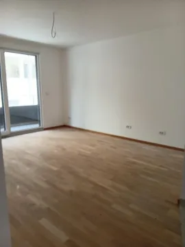 Prazna neopremljena soba sa drvenim podom i balkonskim vratima. - image 2