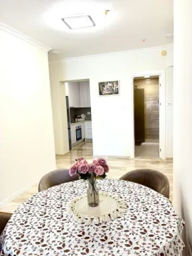Dining table with flowers and a view of the apartment interior. - image 9