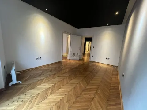 Empty room with wooden parquet flooring and a black ceiling. - image 2