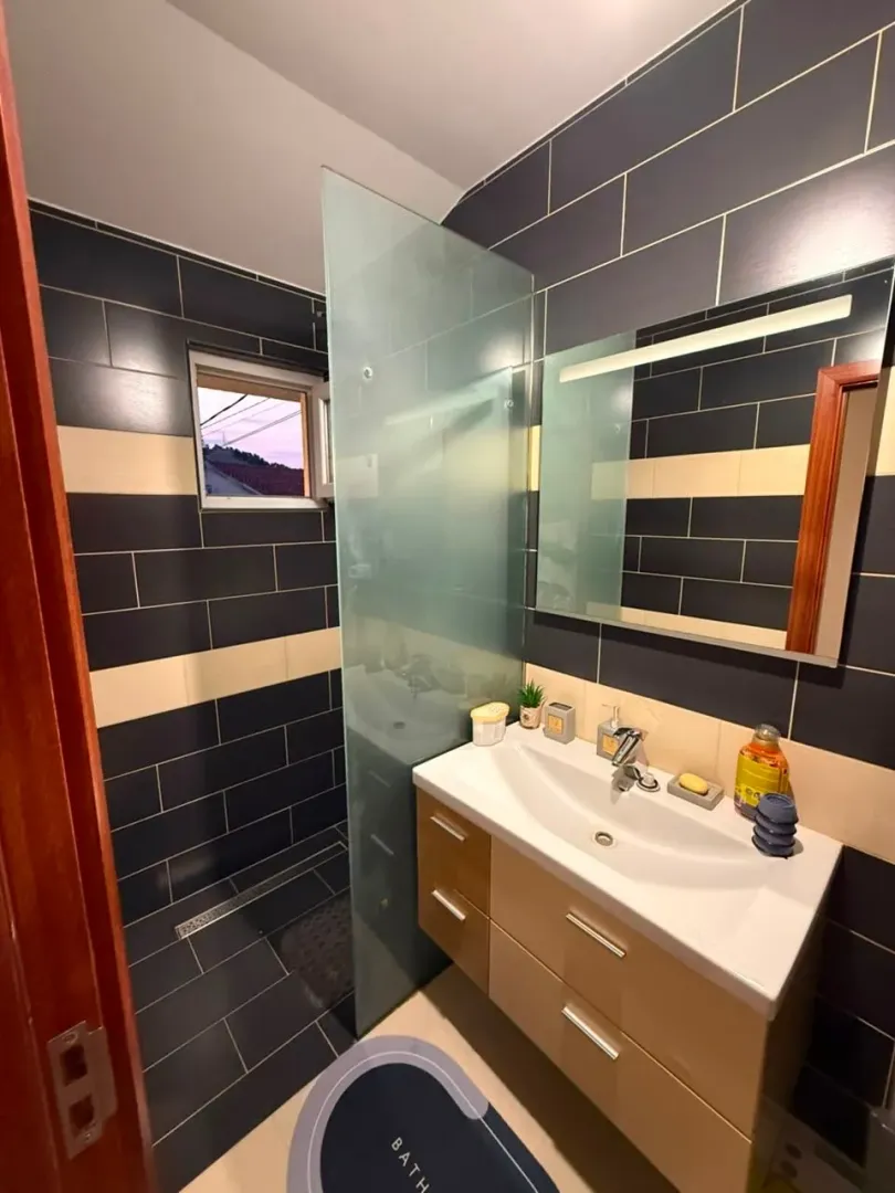 Modernly equipped bathroom with a walk-in shower and vanity with a sink.