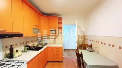 Kitchen with orange units and a dining table. - image 2