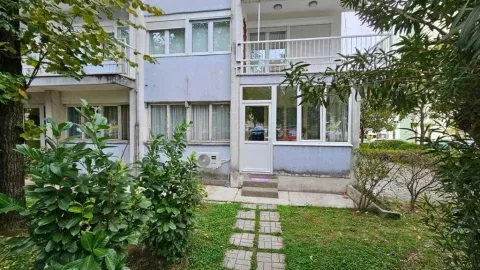 Pogled na ulaz i dvorište stambene zgrade sa zelenilom. - image 3