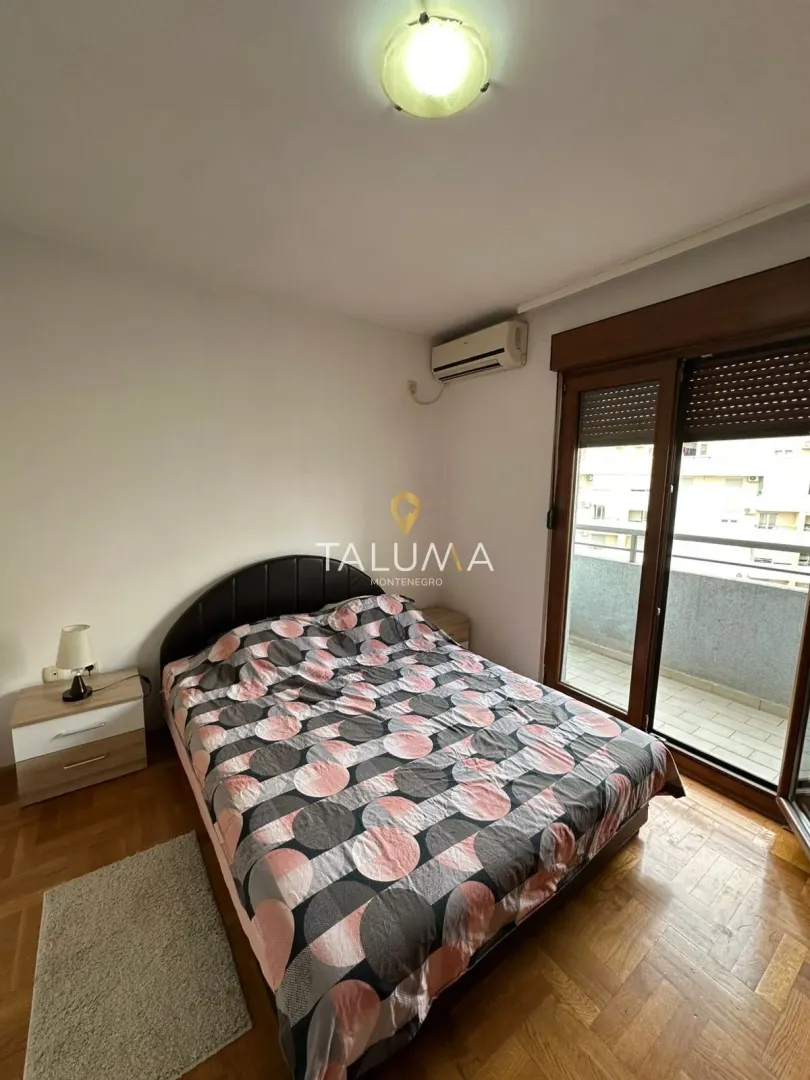 Bedroom with a double bed, nightstand, and balcony access.