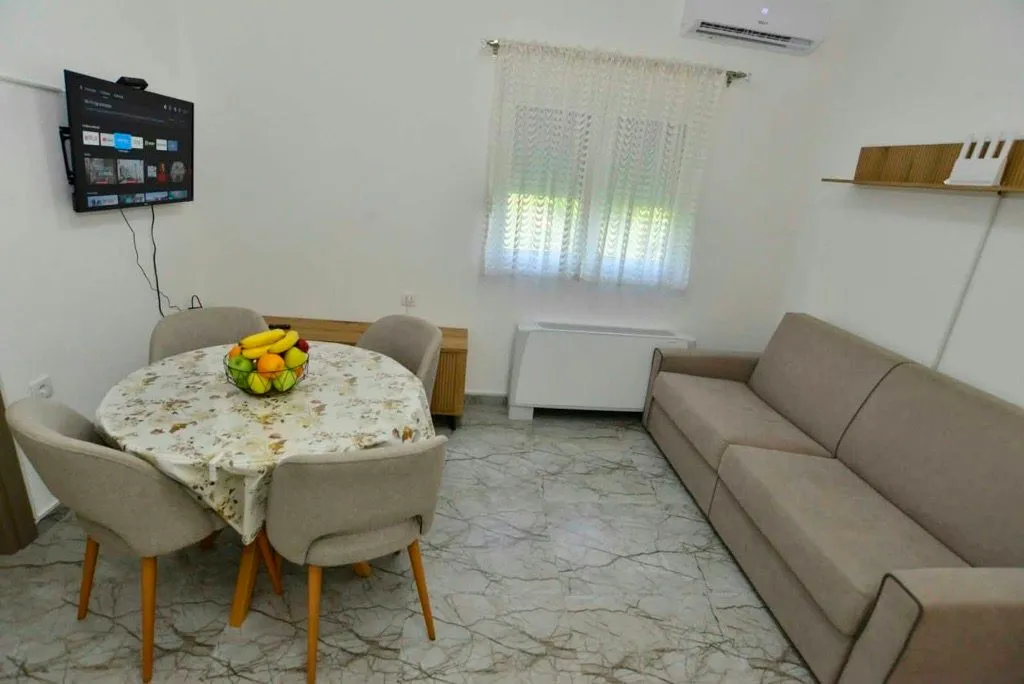 Dnevna soba sa trpezarijskim stolom i garniturom za sjedenje.