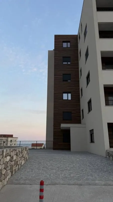 Pogled na spoljašnjost moderne stambene zgrade sa popločanim dvorištem.
