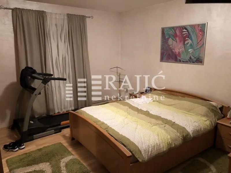 Bedroom with a double bed, curtained window, and a treadmill.