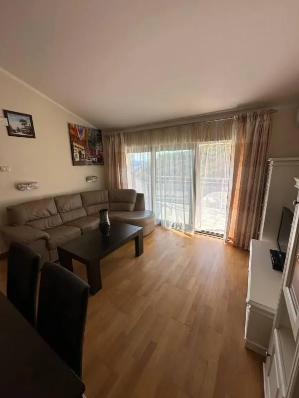 Dnevna soba sa garniturom za sjedenje i izlazom na terasu.