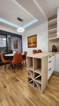 Modern kitchen with a breakfast bar and dining area. - image 8