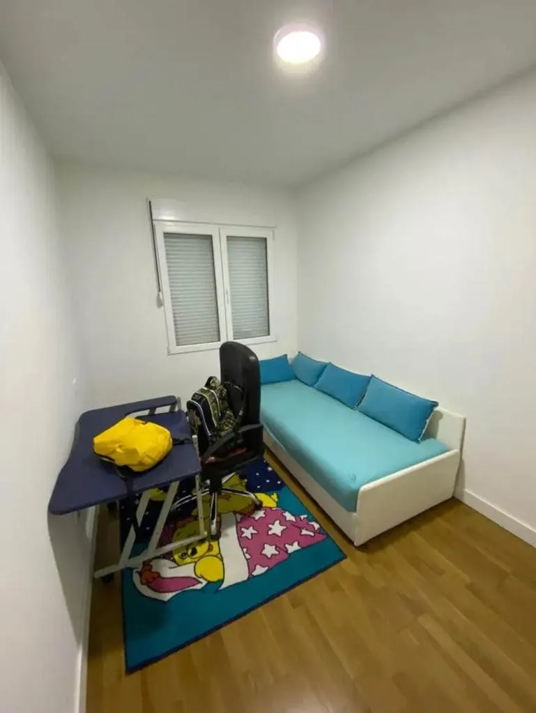Children's bedroom with a bed, desk, and a window.
