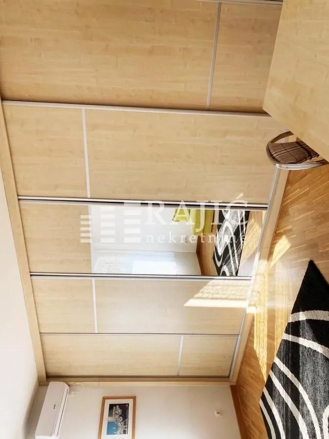 Bedroom with a large fitted wardrobe and wooden floor.
