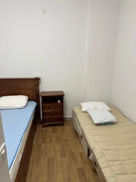 Spavaća soba sa dva kreveta i noćnim stočićem. - image 11