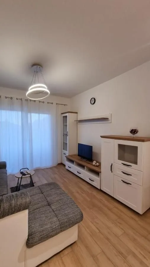 Living room with a sofa, TV unit, and white furniture.